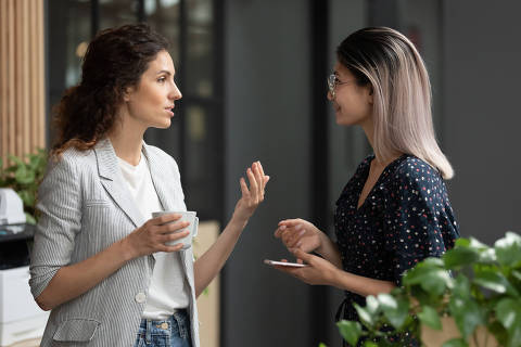Head shot side view young confident smart caucasian female team leader explaining project details to interested smiling vietnamese colleague. Diverse employees chatting during coffee break at office.Credit  Fizkes / Adobe Stock
